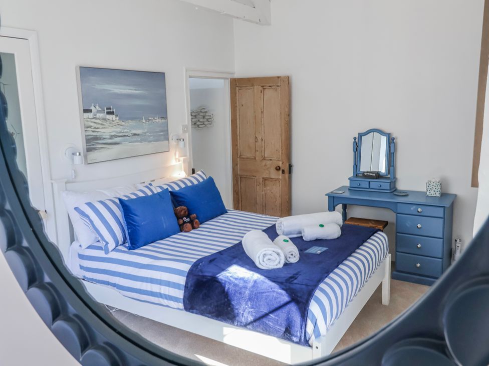 A bedroom with a bed and dresser at Hideaway Cottage