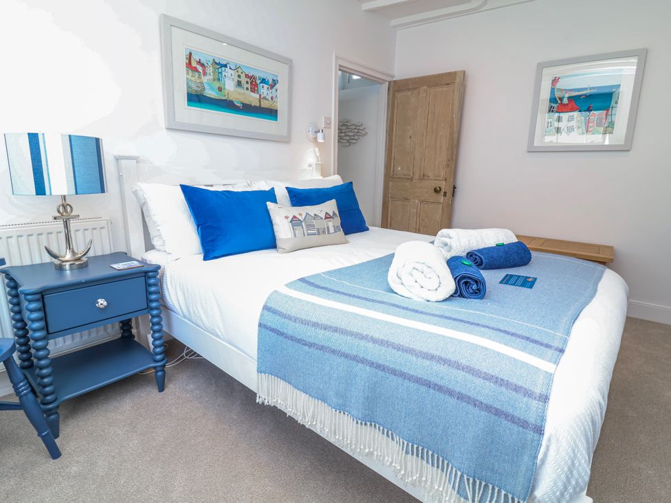 A bedroom with a bed and lamp at Hideaway Cottage