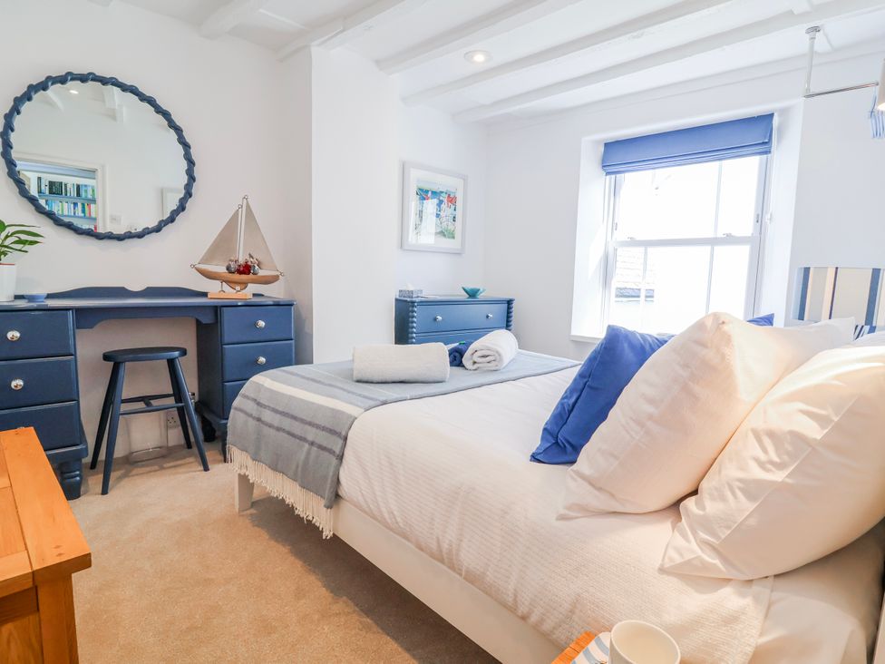 A bedroom with a bed and desk at Hideaway Cottage