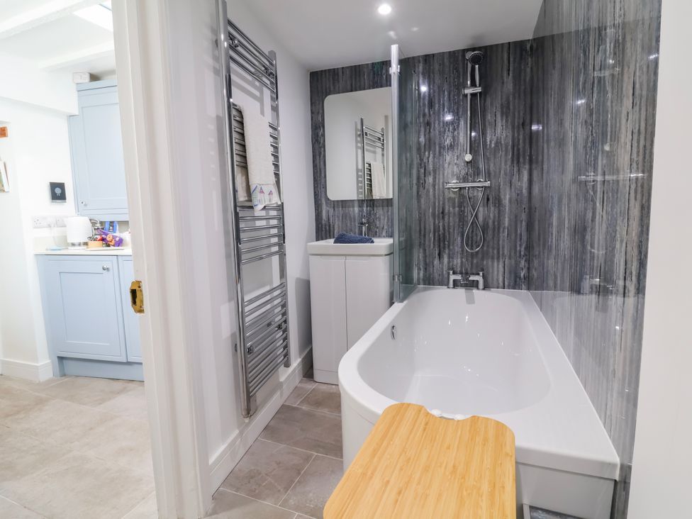 A bathroom with bathtub and shower at Hideaway Cottage