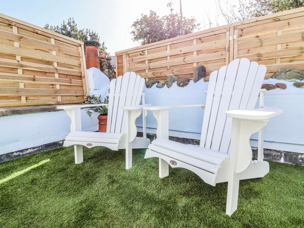 Adirondack chairs in a garden at Hideaway Cottage