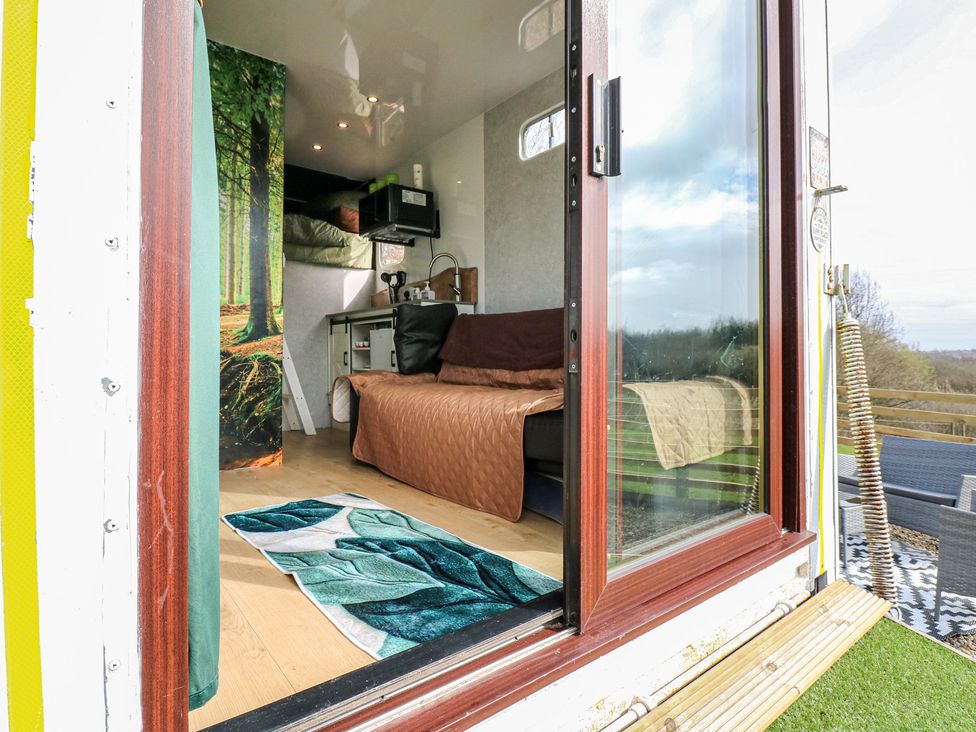 A living room with a sofa and kitchenette at The Horse Box in Blaydon-on-Tyne