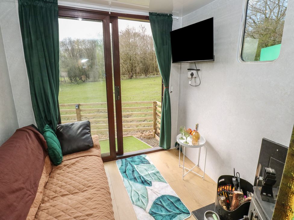 A living room with a sofa, TV, and table at The Horse Box in Blaydon-on-Tyne