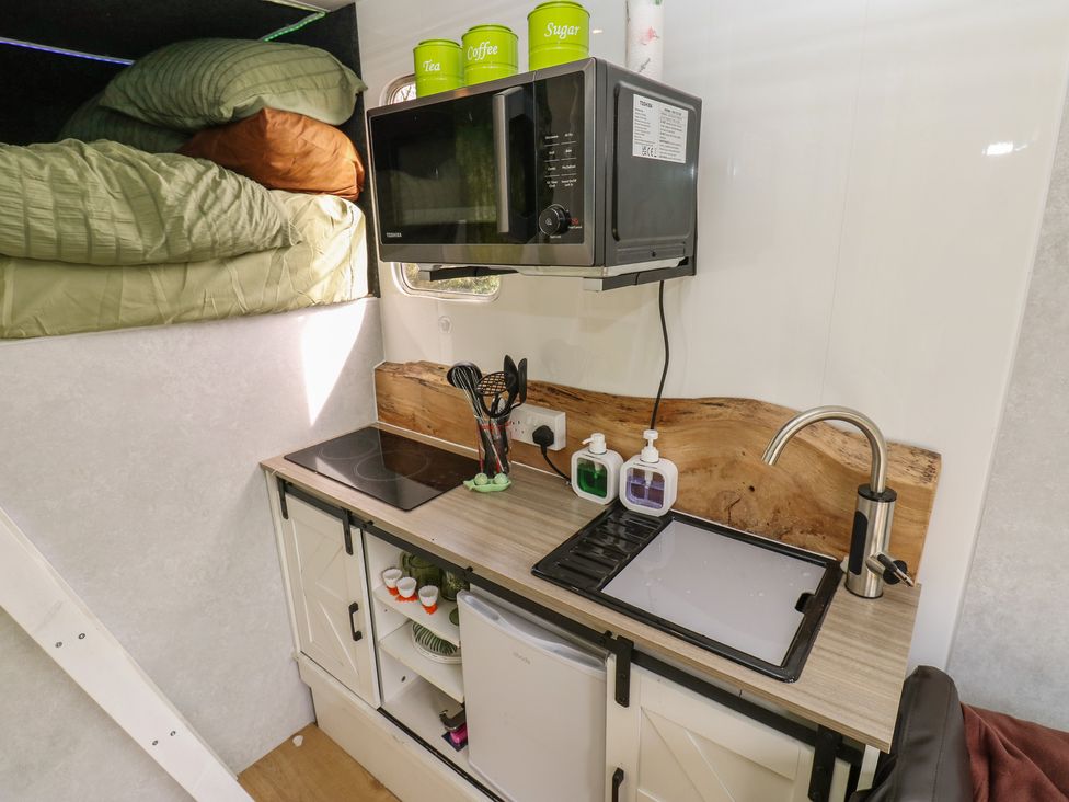 A kitchen with a stove and microwave at The Horse Box in Blaydon-on-Tyne