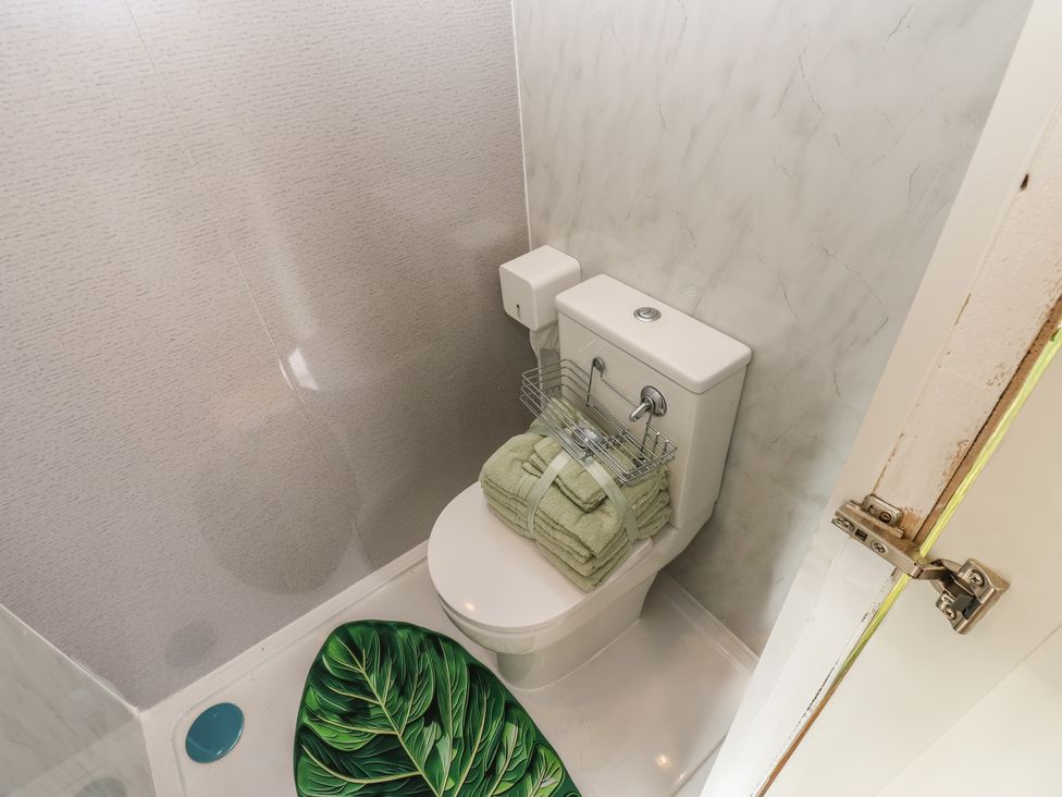 A bathroom with a toilet, towels on a rack, and a shower at The Horse Box in Blaydon-on-Tyne