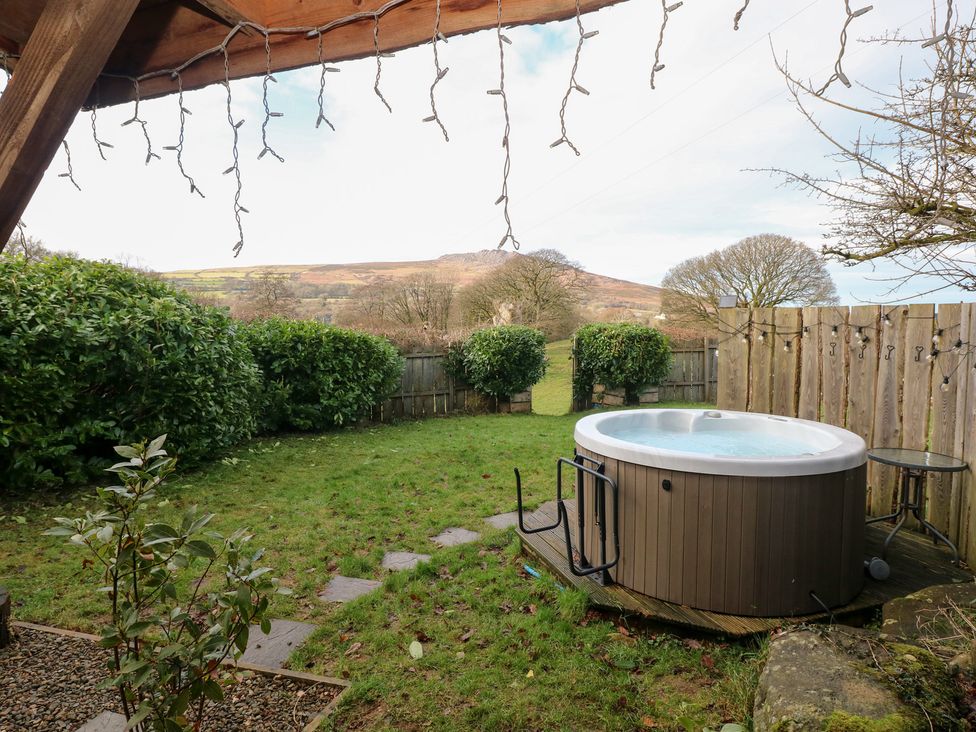 A garden with a hot tub and bushes at Cabin in Newport