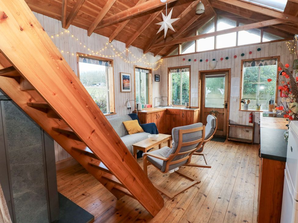 A living room with wooden stairs and furniture at Cabin in Newport