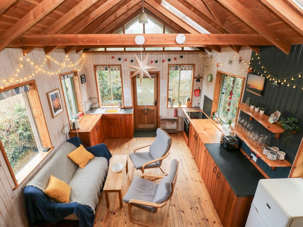 A living room with a sofa and kitchen at Cabin in Newport