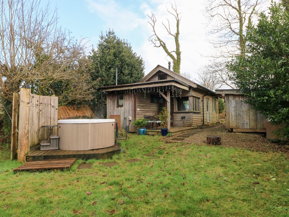 A garden with a wooden house and hot tub at Cabin in Newport