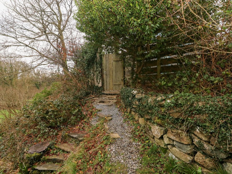 A pathway leading to a gate surrounded by greenery at the Cabin in Newport