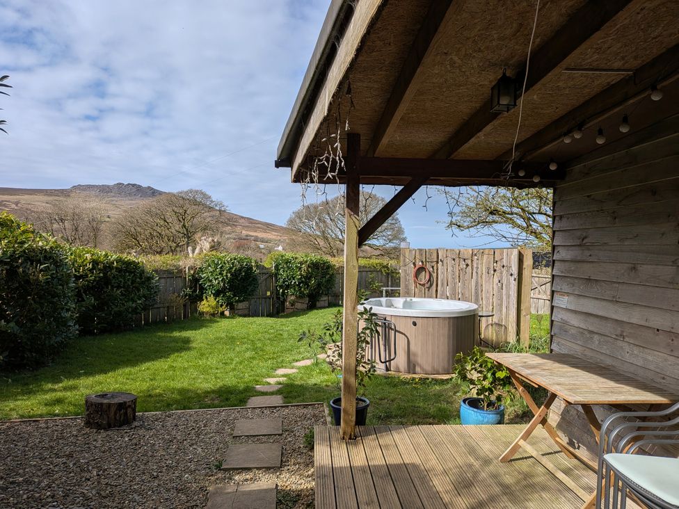 A garden with a hot tub and seating area at Cosy Eco Cabin in Cilgwyn near Newport, Pembrokeshire