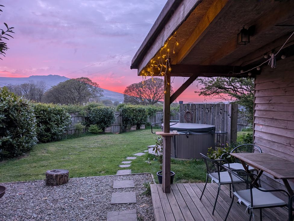 A garden with a hot tub and seating area at Cosy Eco Cabin in Cilgwyn near Newport, Pembrokeshire