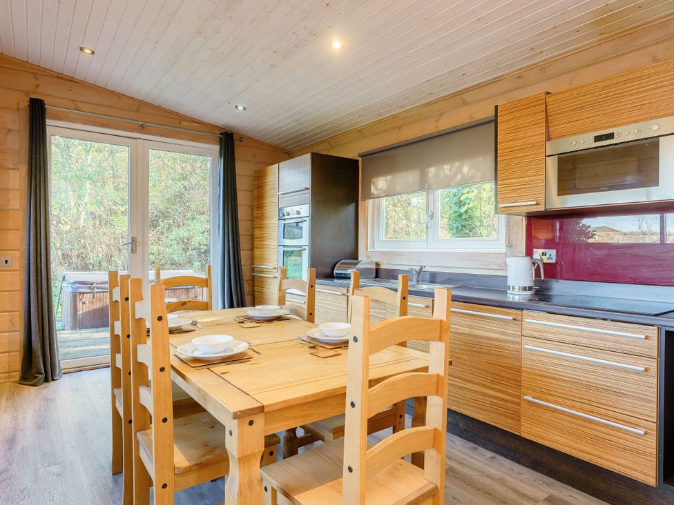 A kitchen with a dining table and chairs at Poplar Lodge (Pet) Thirsk