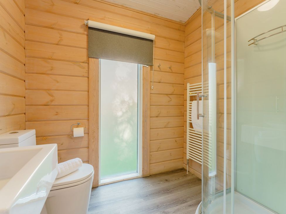 A bathroom with a toilet, sink, shower, and towel rail at Poplar Lodge (Pet) Thirsk