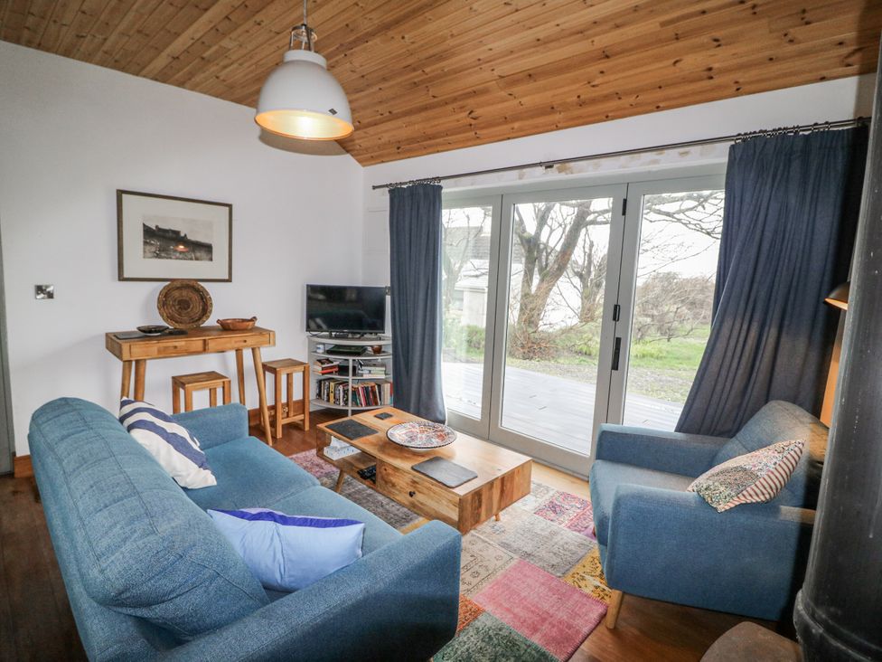 A living room with a sofa and television at The Faithfuls Cabin in Dingle