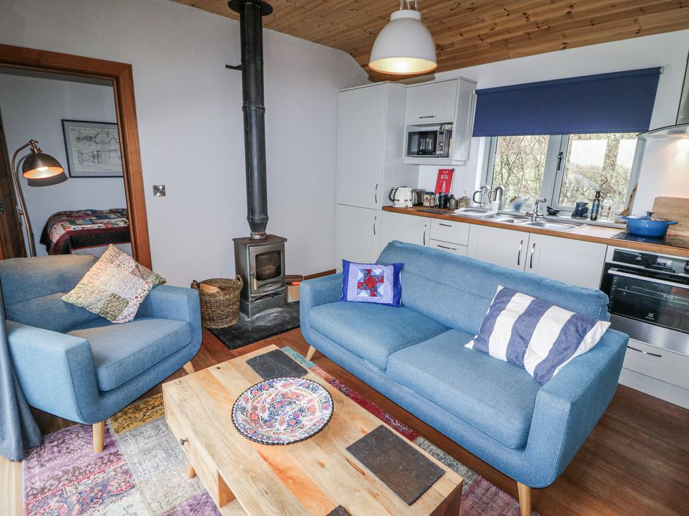 A living room with a sofa and stove at The Faithfuls Cabin in Dingle