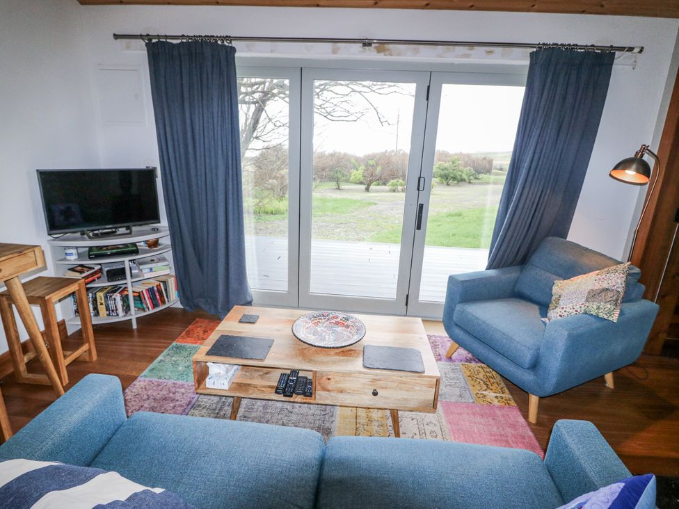 A living room with a sofa and tv at The Faithfuls Cabin in Dingle