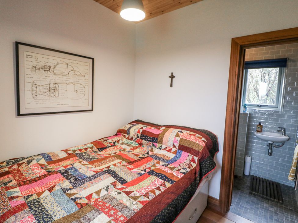 A bedroom with a bed and a sink at The Faithfuls Cabin in Dingle