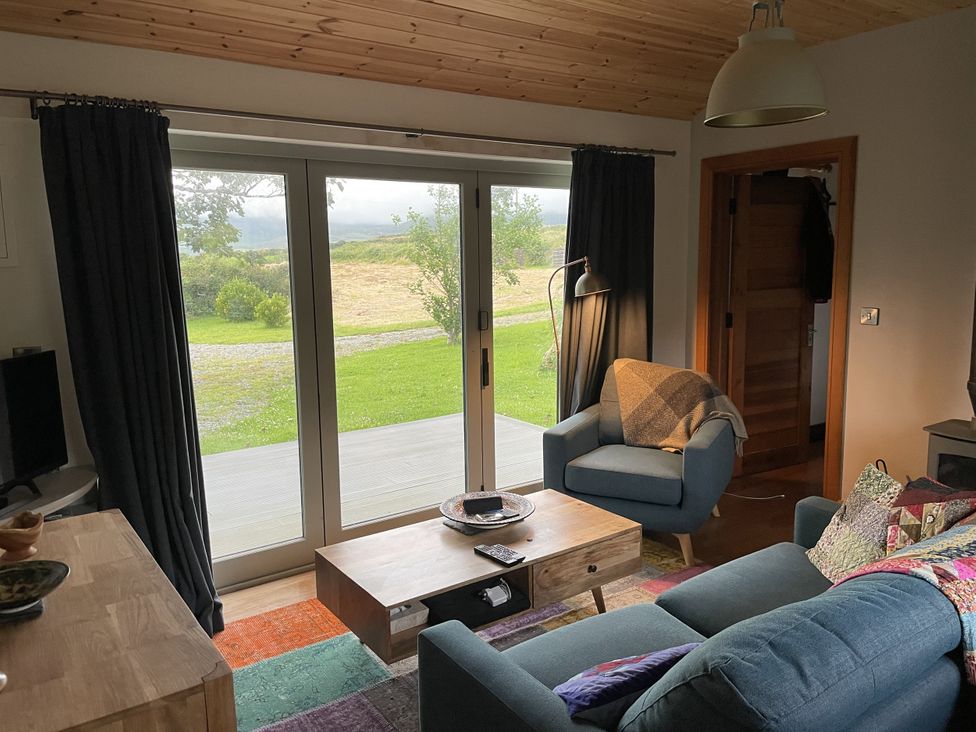 A living room with a sofa and armchair at The Faithfuls Cabin in Dingle, County Kerry