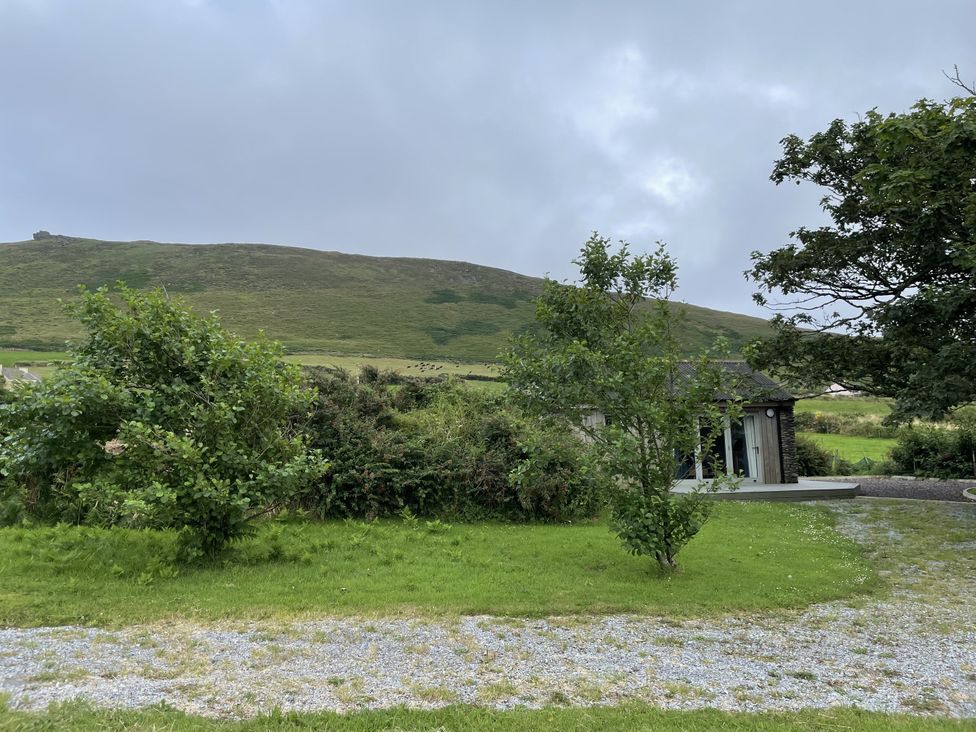 A view of a house with trees and mountains at The Faithfuls Cabin in Dingle, County Kerry