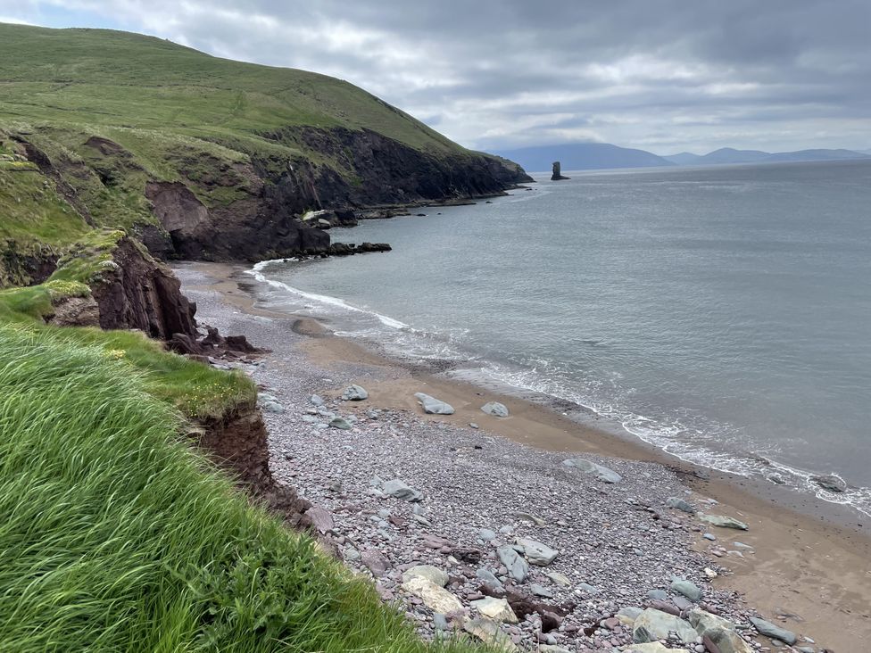 A shoreline with rocks and grass at The Faithfuls Cabin in Dingle, County Kerry