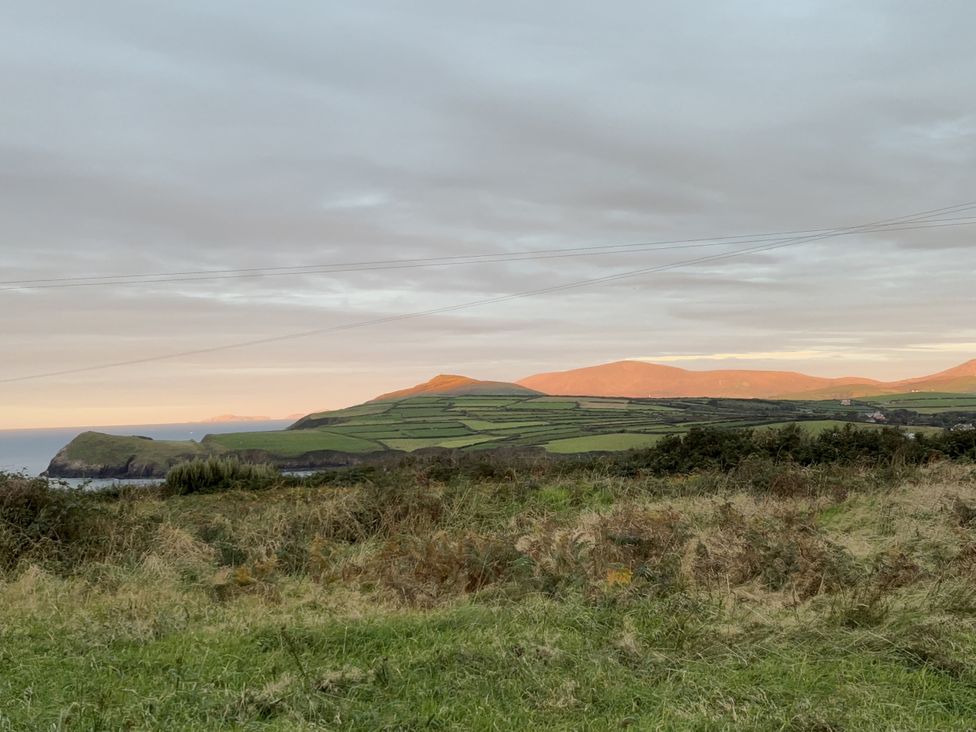 A landscape view of hills and fields by the ocean at The Faithfuls Cabin in Dingle, County Kerry
