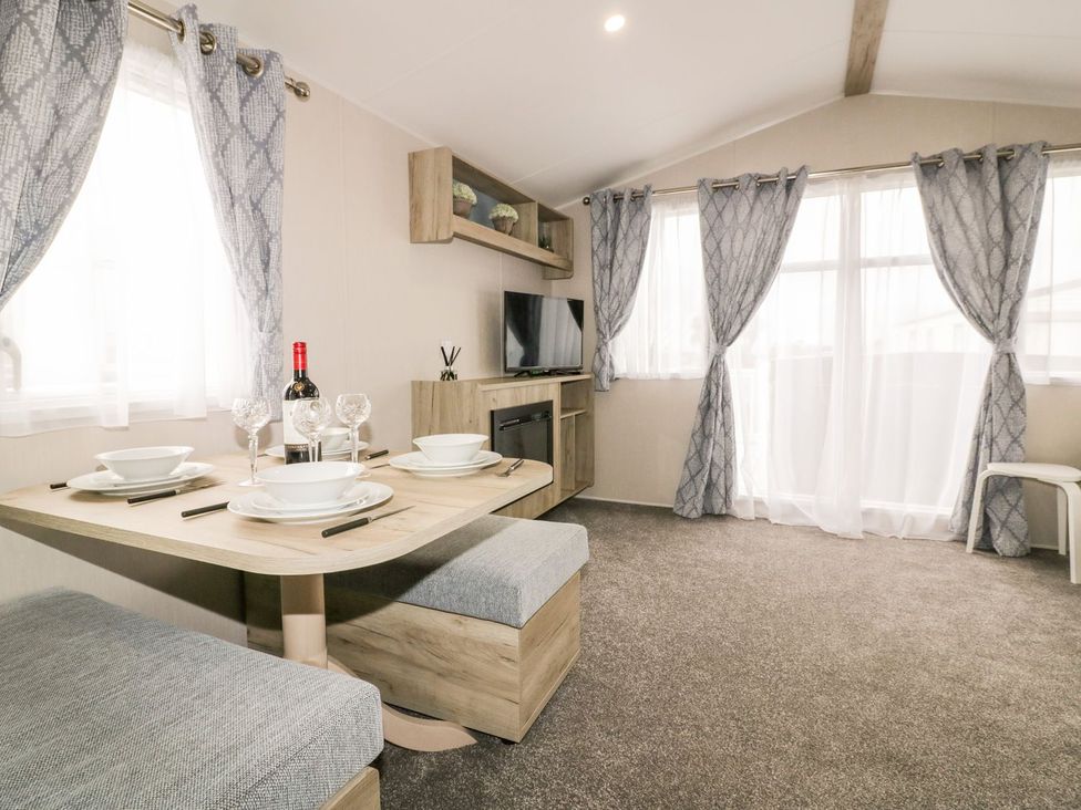 A living room with a dining table and tv at Barney's Retreat in Newquay