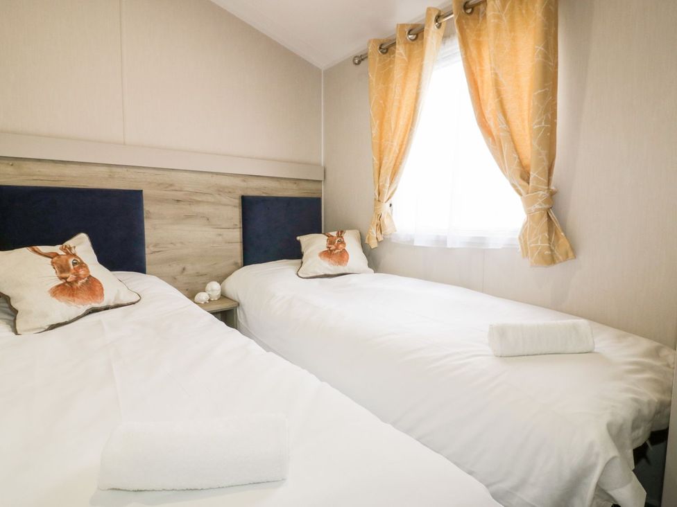 A bedroom with two single beds and window at Barney's Retreat in Newquay