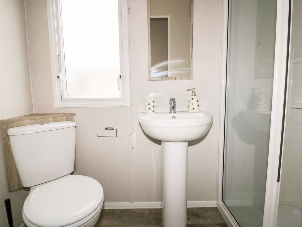 A bathroom with a toilet, sink, and shower at Barney's Retreat in Newquay
