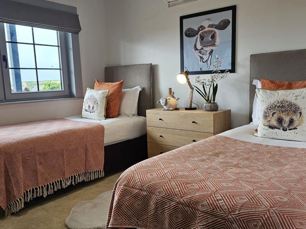 Two single beds with pillows and a nightstand at Kinder Lodge 3 Portreath