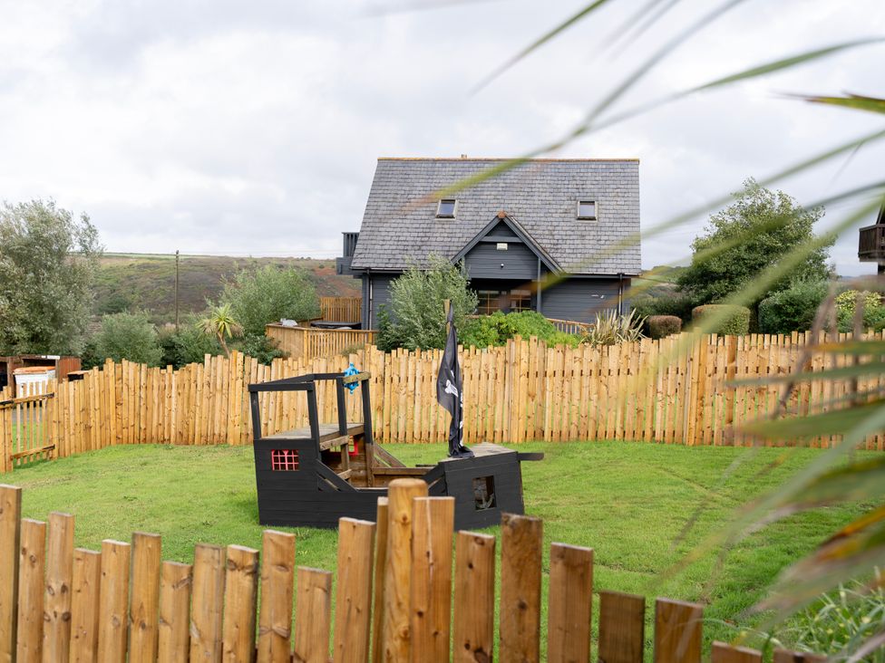 An outdoor space with a pirate ship and fence at Kinder Lodge 3 Spa (Pet) Redruth
