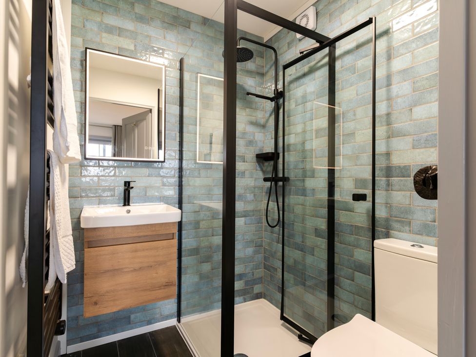 A bathroom with a shower, sink, and toilet at Kinder Lodge 3 Spa (Pet) in Redruth