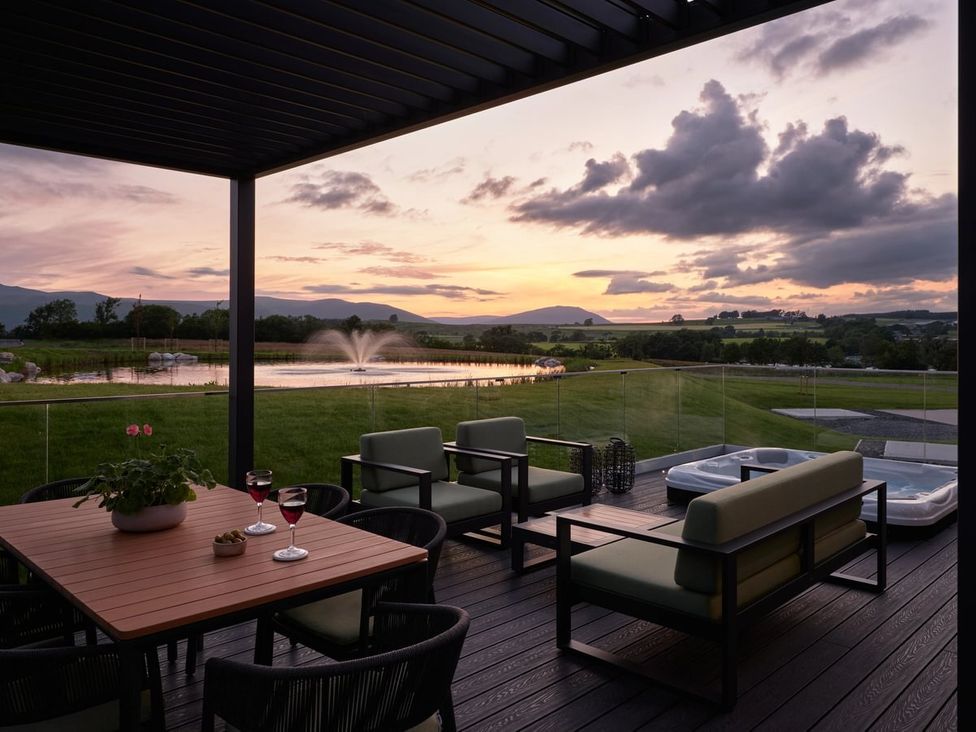 An outdoor area with seating and a hot tub at Wansfell (Pet) Penrith