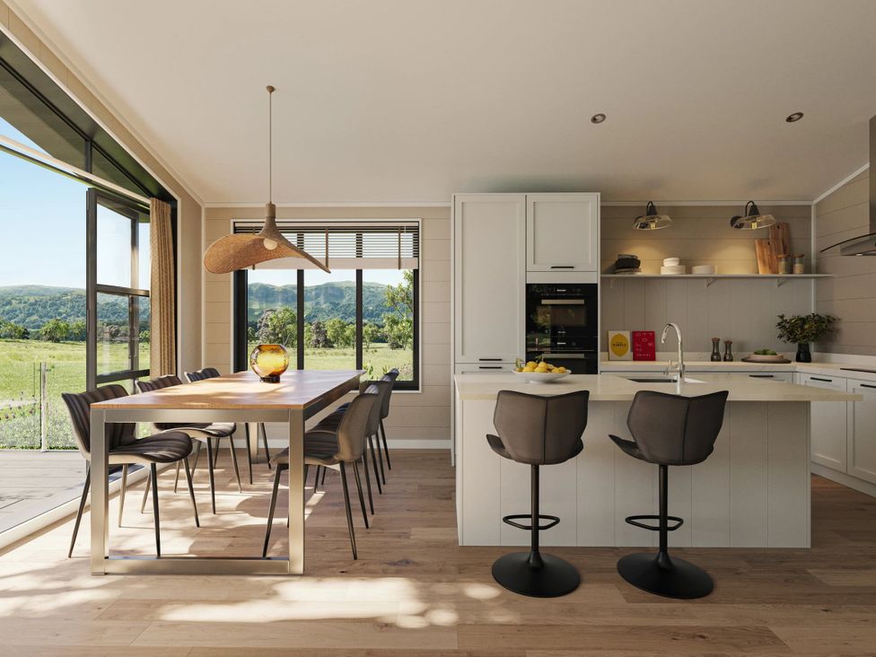 A kitchen with a dining table and bar stools at Fell Side (Pet) Penrith