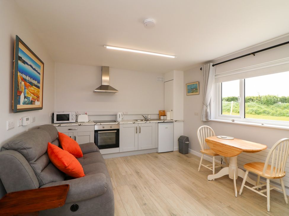 A kitchen with a sofa and dining table at Radharc an Hook @ Estuary Bliss