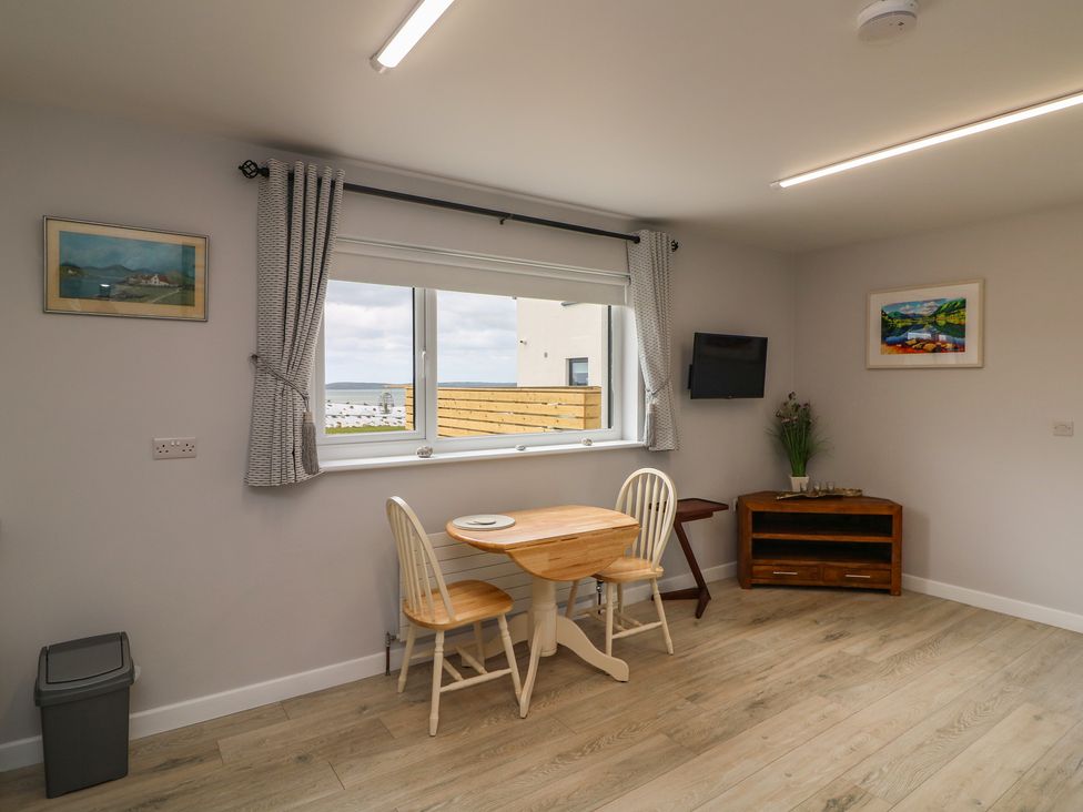 A dining room with a table and chairs at Radharc an Hook @ Estuary Bliss