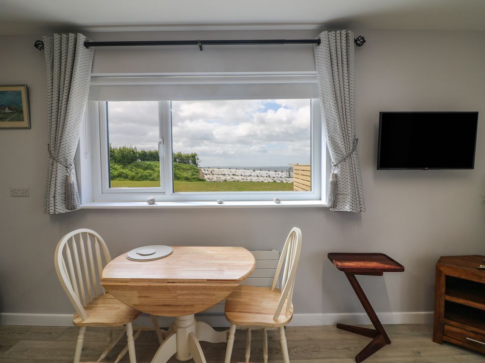 A dining room with a table and chairs at Radharc an Hook @ Estuary Bliss
