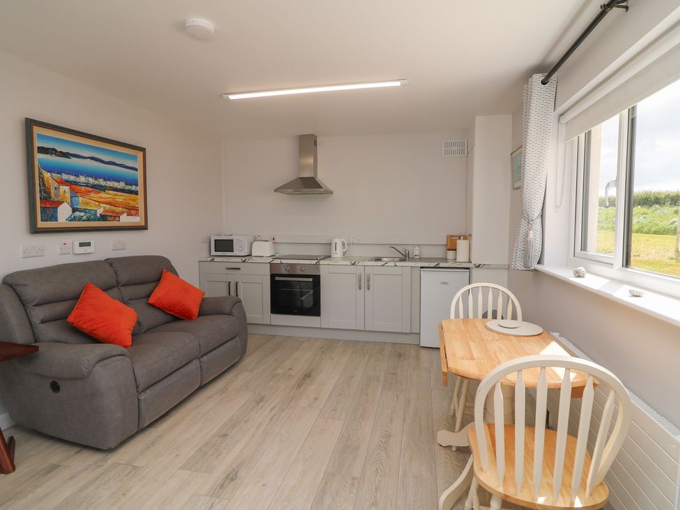 A kitchen with a sofa and dining table at Radharc an Hook @ Estuary Bliss