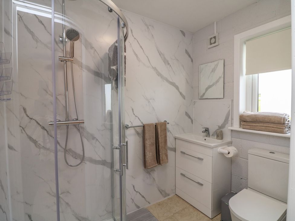 A bathroom with shower, sink, toilet, and towels at Radharc an Hook @ Estuary Bliss
