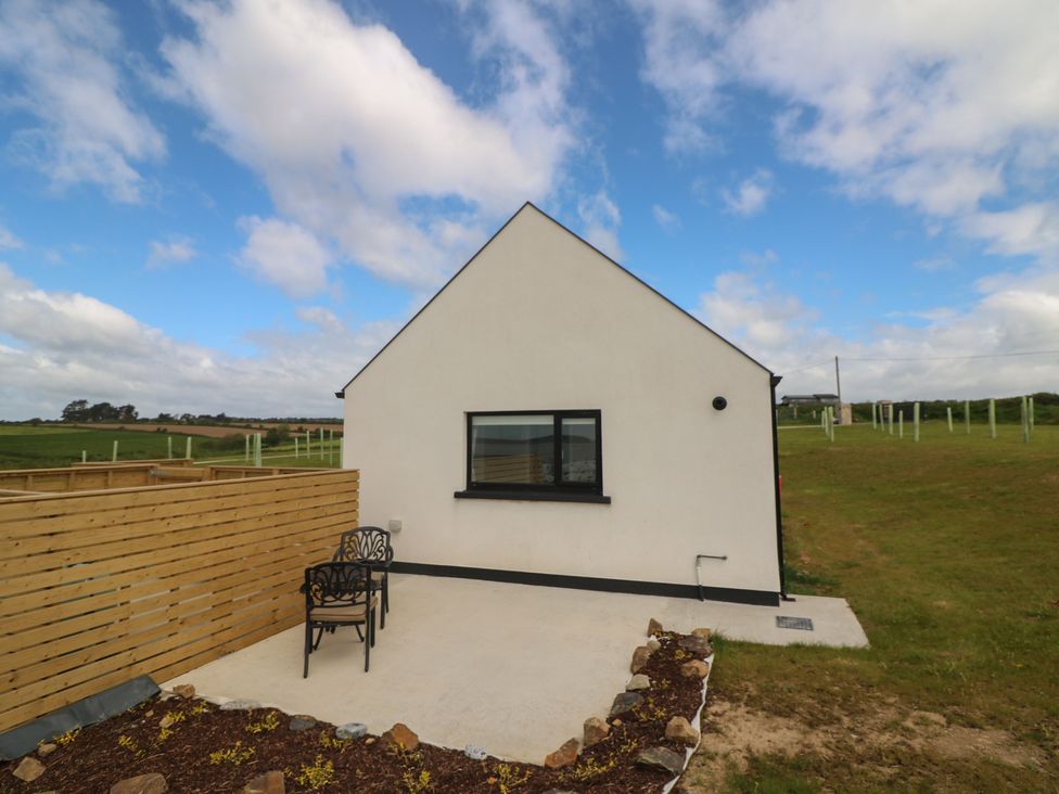 An outdoor area with a house and chairs at Radharc an Hook @ Estuary Bliss