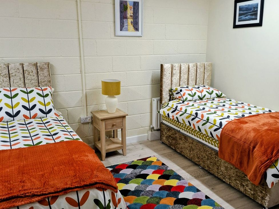 A bedroom with two beds and a bedside table at Radharc an Hook @ Estuary Bliss, Duncannon, County Wexford