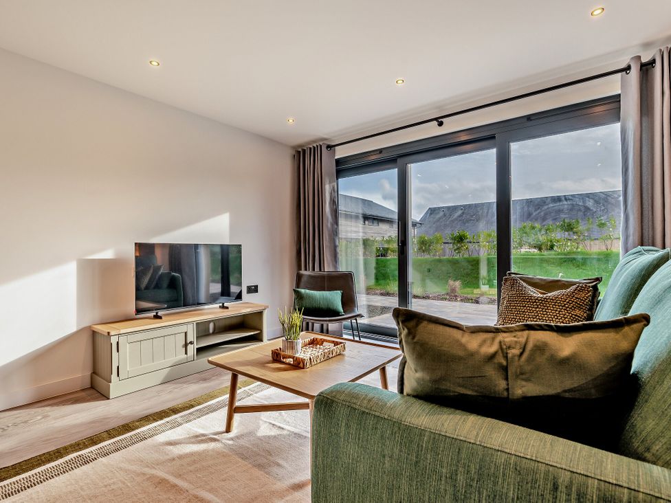 A living room with a television, sofa, and coffee table at Arvor Wetroom Studio 1.0