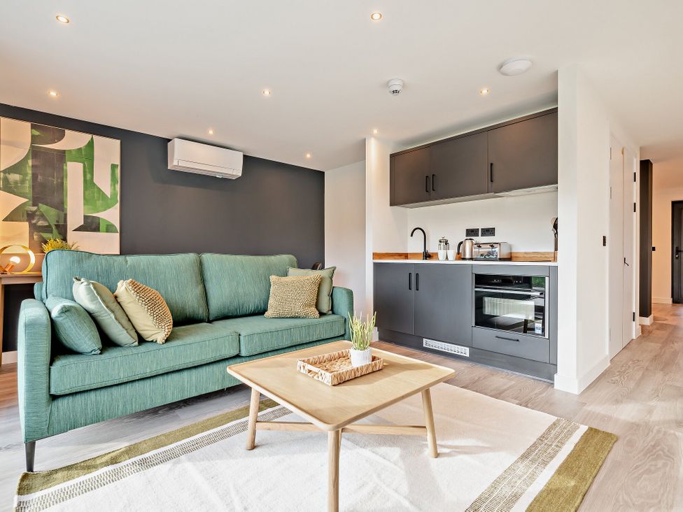 A living room with a sofa and kitchen unit at Arvor Wetroom Studio 1.0