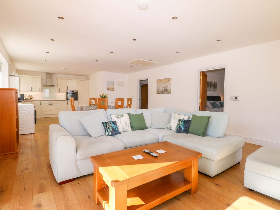 A living room with a sofa and dining area at Blue Bell Cottage near Lenham