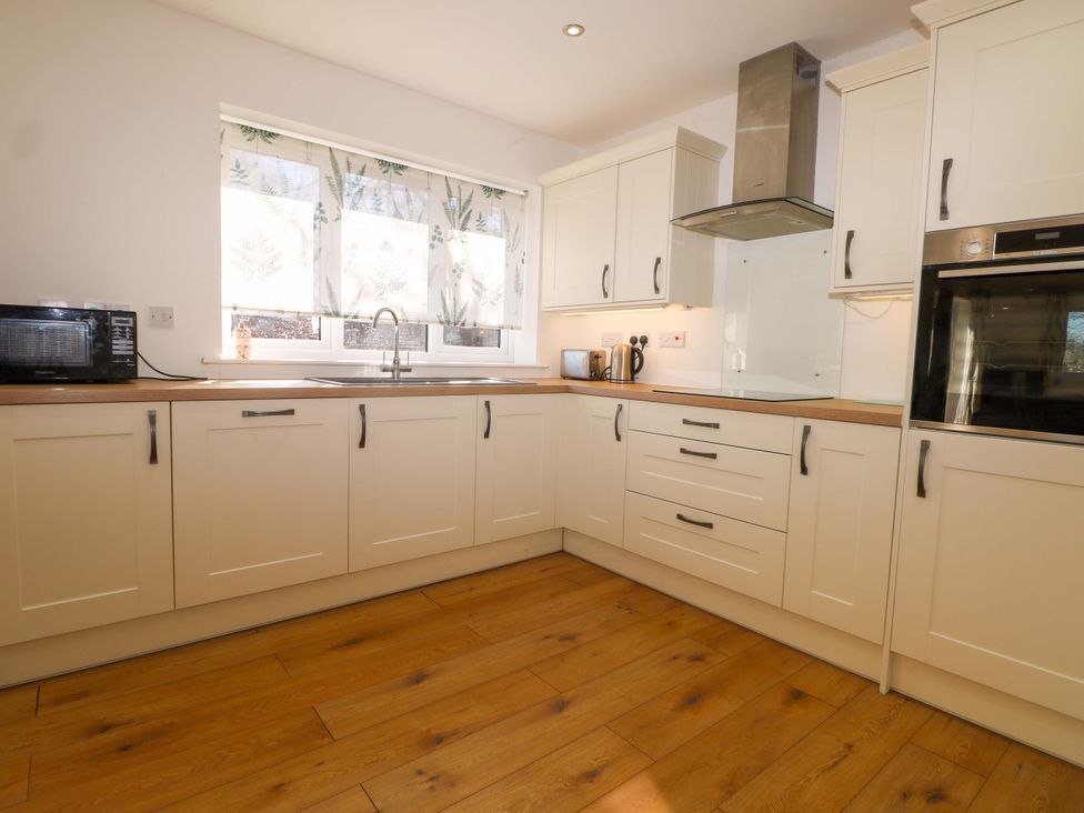 A kitchen with a sink and microwave at Blue Bell Cottage near Lenham