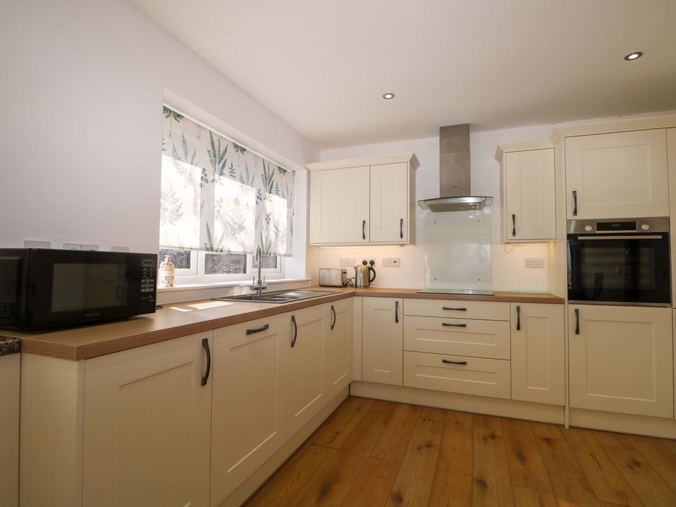 A kitchen with cabinets and appliances at Blue Bell Cottage near Lenham