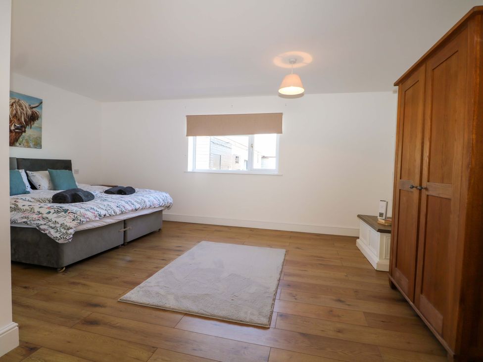 A bedroom with a bed, wardrobe, and a window at Blue Bell Cottage near Lenham