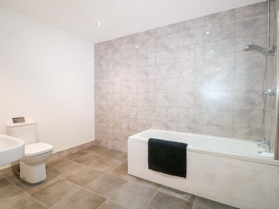 A bathroom with a bathtub and toilet at Blue Bell Cottage near Lenham