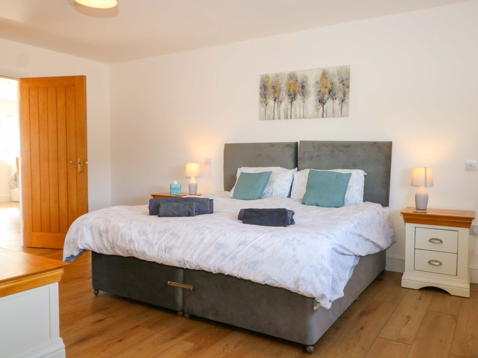 A bedroom with a bed and nightstand at Blue Bell Cottage near Lenham