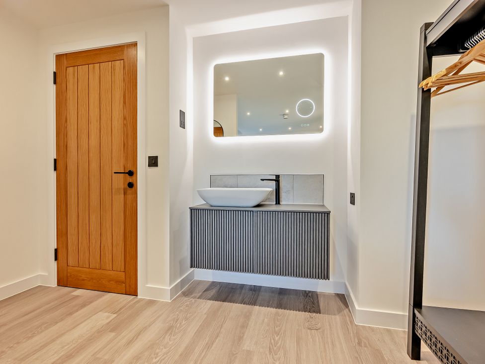 A bathroom with a sink and mirror at Whalesborough Penthouse 2.0 Marhamchurch